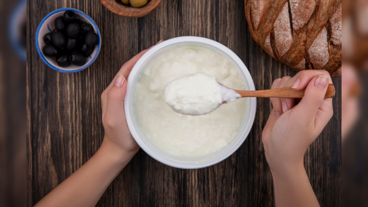 6. Greek Yogurt / Hung Curd (10g protein per 100g)- Thick hung curd in a glass bowl with spoon.
